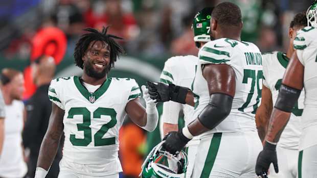 Jets' RB Michael Carter interacts with teammate Laken Tomlinson